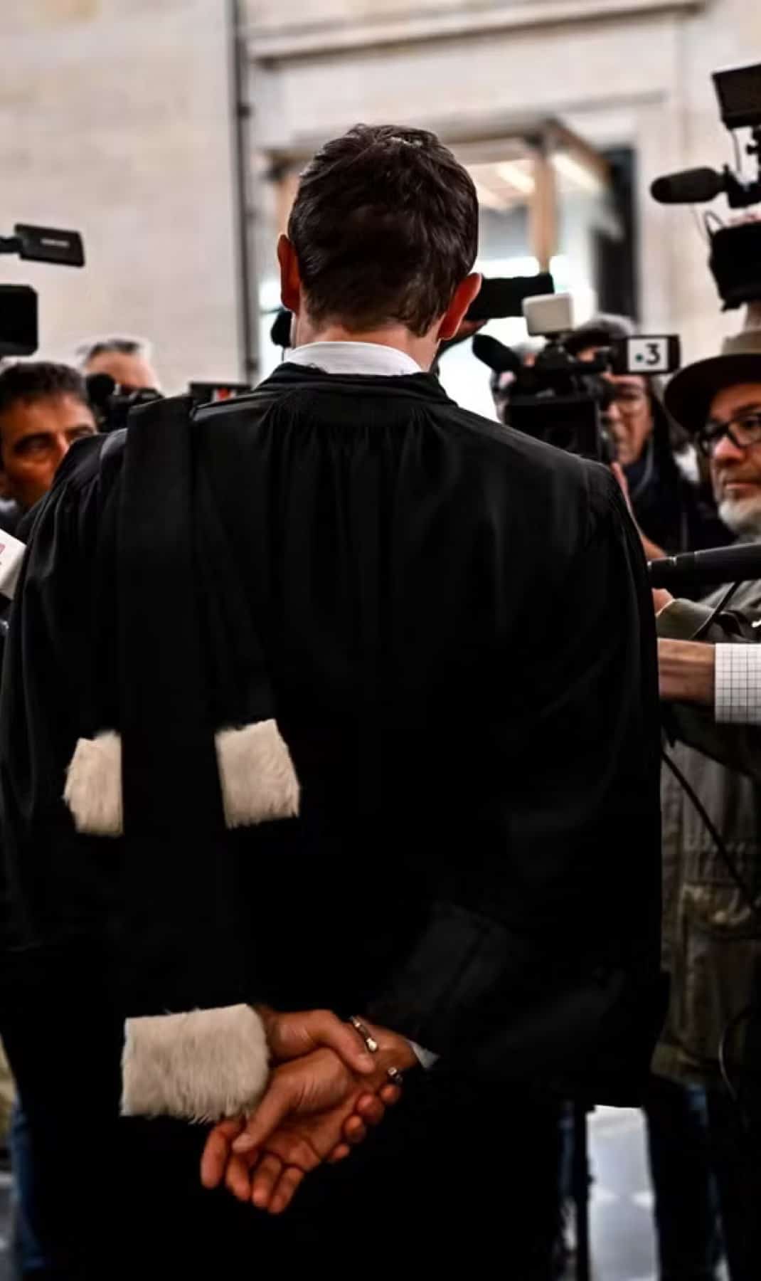 Maître Julien Plouton, en robe, face aux caméras et aux micros de la presse à l’issue d’une audience.